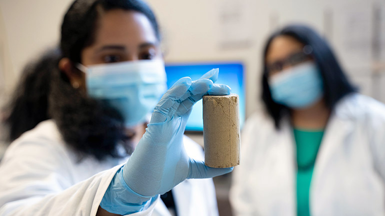 UBCO postdoctoral research fellow Chinchu Cherian, along with Associate Professor Sumi Siddiqua, examines a road building material created partly with recycled wood ash. 