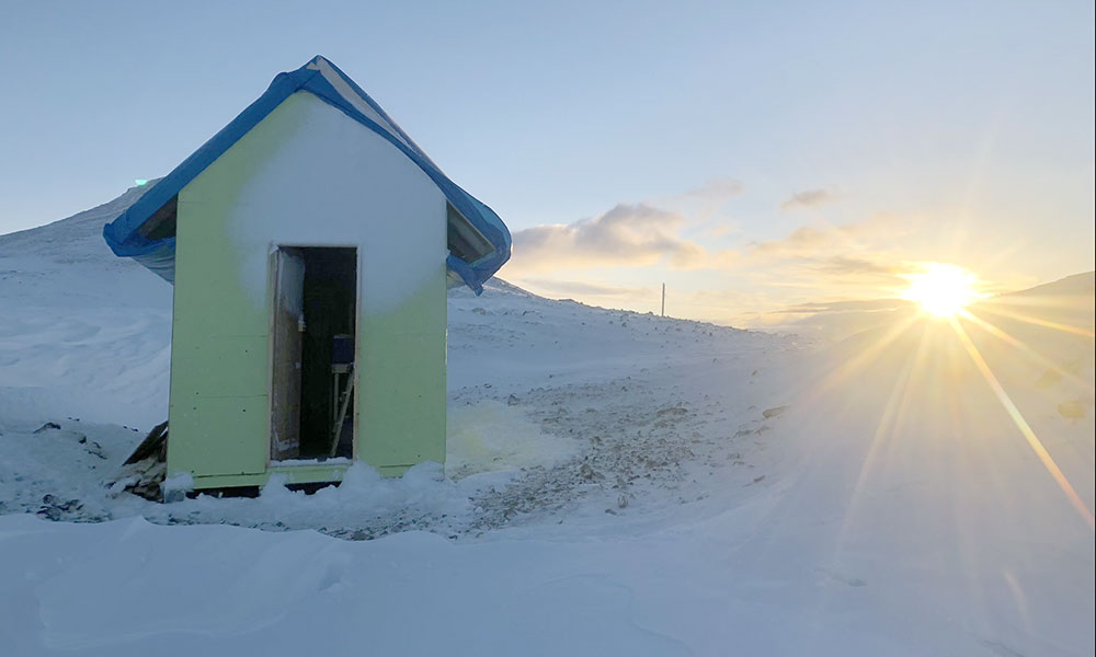 The sun sets on a makeshift survival shelter at 7,000 feet near the Andrei Ice field in northwestern British Columbia.